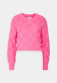 Kortad tröja i ljus rosa med ett texturerat rutmönster. Har långa ärmar samt ribbade muddar och fåll. Tillverkad av ett mjukt stickmaterial.