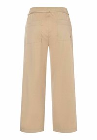 Beige weite Hosen mit elastischem Bund, zwei Gesäßtaschen und glatter Textur. Das Design ist minimalistisch und funktional.