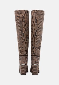 Bottes marron à motif serpent, montantes jusqu'aux genoux, avec une finition texturée, des talons carrés et une fermeture éclair à l'arrière. Accentuation avec des détails noirs.