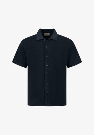 Rövid ujjú sötét tengerészkék ing, geometrikus mintával, gombos előlappal és galléros nyakkal. Puha tapintású, laza fazonú.