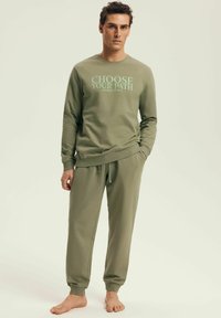 Olive green sweatshirt and matching joggers made of soft material; sweatshirt features "CHOOSE YOUR PATH" printed in light blue.