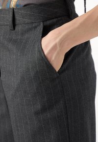 Grå stripete bukser med teksturert stoff, med sidelomme og skreddersydd midje.