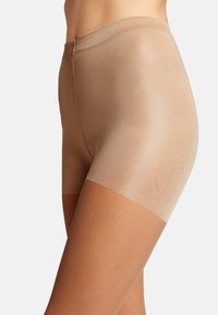 Beige semi-gennemsigtige shorts med en blød, glat tekstur og elastisk talje. Har en tætsiddende pasform og midt-lår længde.