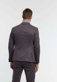 Férfi szabott öltöny sötétlila anyagból. Slim fit, strukturált vállakkal, notch gallérral és dupla hasítékkal a hátrészén. Texturált felület.