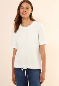 T-shirt en coton blanc à manches courtes, col rond et détail de poche texturé. Comprend un ourlet à cordon de serrage pour un ajustement réglable.