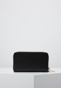 Černá kožená peněženka na zip s texturovaným povrchem, obdélníkovým tvarem a zlatými kovovými detaily. Žádné viditelné vzory ani loga.