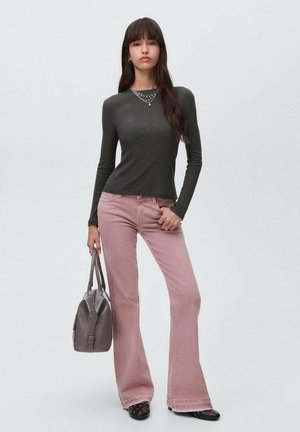 Tummanvihreä pitkähihainen paita, vaaleanpunaiset leveälahkeiset farkut ja harmaa käsilaukku. Mallilla on kerroskoru ja mustat korkokengät. Sileät pinnat.