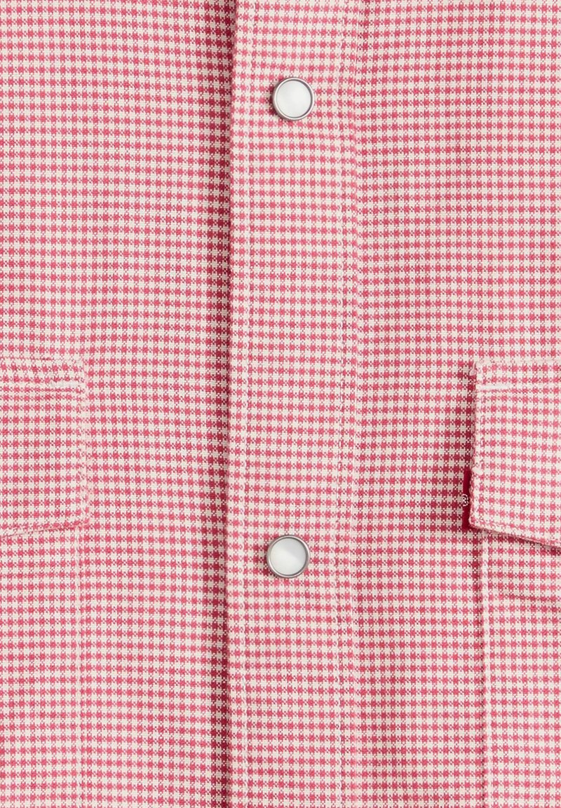 Tessuto a quadretti rosa e bianco con due bottoni automatici bianchi e dettagli a patta visibili su entrambi i lati.