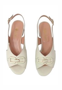 Tacchi a spillo bianchi con apertura frontale, dotati di una fibbia decorativa nella parte anteriore. Materiale in pelle liscia con una soletta rosa chiaro.