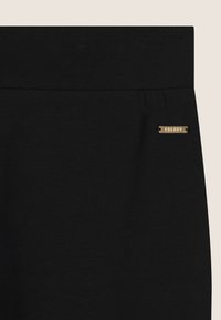 Pantaloni in tessuto elasticizzato nero con una superficie liscia, dotati di una fascia larga in vita e un piccolo accento dorato con il logo "FREDDY" sul lato.