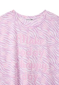 T-shirt rosa chiaro con un motivo a strisce di zebra, con la scritta "Rendi oggi una giornata felice" in grassetto, con lettere bianche in contrasto.