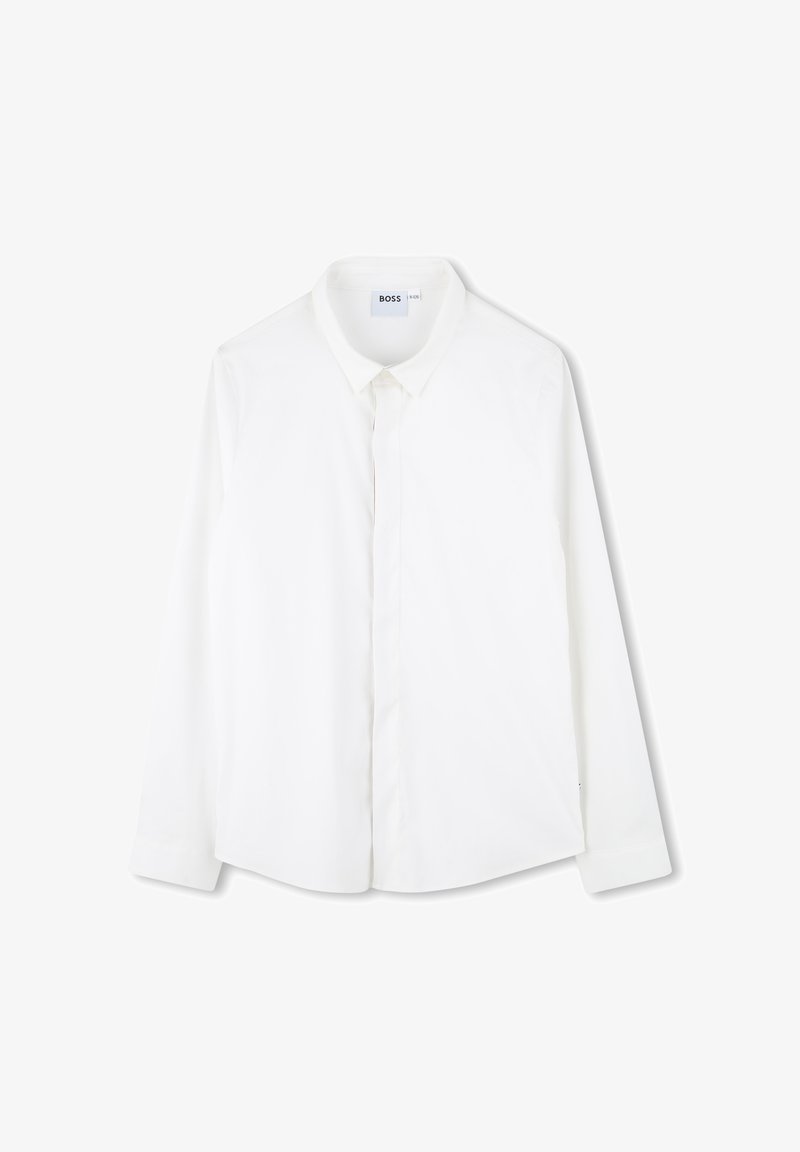 Camicia bianca a maniche lunghe realizzata in tessuto liscio. Presenta un colletto classico, una patta frontale e un orlo leggermente curvo. Etichetta con logo sul collo.