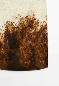 Tissu tie-dye marron et crème avec une surface texturée, légèrement froissée, et des taches irrégulières marron foncé sur un fond plus clair.