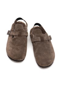 Zoccoli in suede marrone con un interno morbido e peloso, cintura regolabile e design con tacco aperto. La suola in gomma offre aderenza e durata.