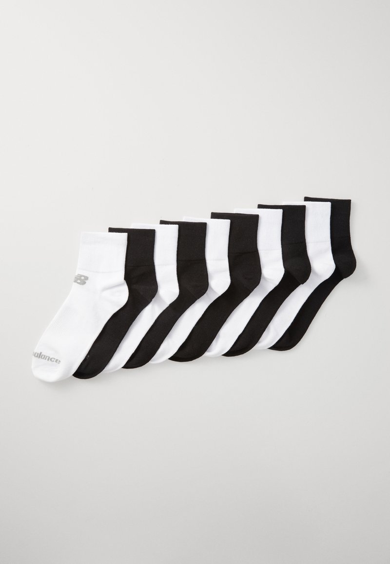 Oito pares de meias de tornozelo dispostas em cores alternadas de preto e branco, apresentando um pequeno logótipo em uma das meias brancas.