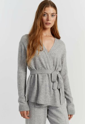 Grijze wikkeltrui van zachte stof met lange mouwen en geribbelde manchetten, voorzien van een strik in de taille en een V-hals design.