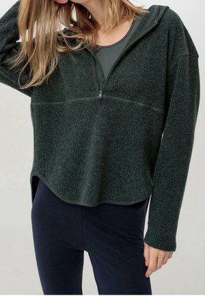 Donkergroene fleecetruien met een halve ritssluiting aan de voorkant, lange mouwen en een ontspannen pasvorm. Heeft een gebogen zoom en een gestructureerd oppervlak.