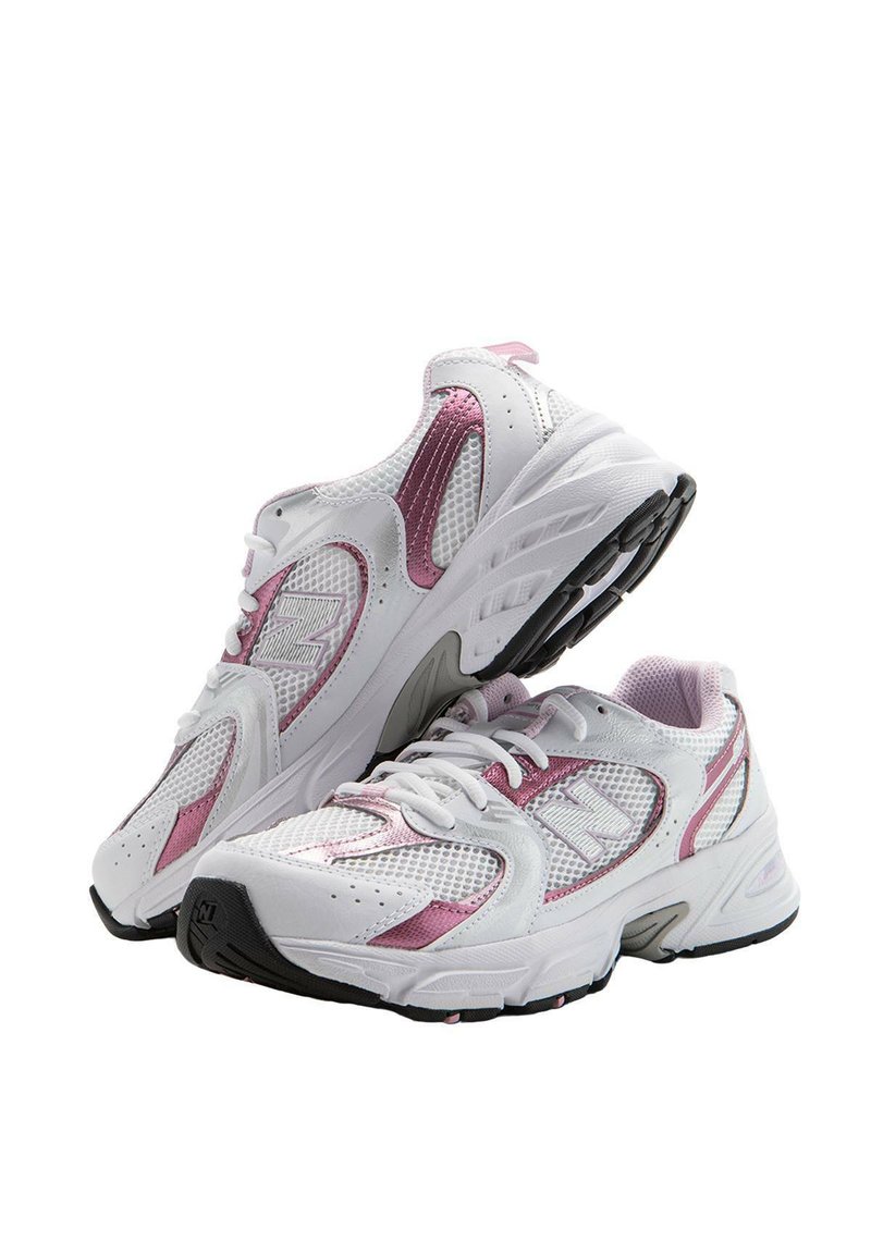 Zapatillas de malla blancas con acentos en rosa, que presentan un diseño de cordones, cuello acolchado y una suela de goma negra para mayor tracción.