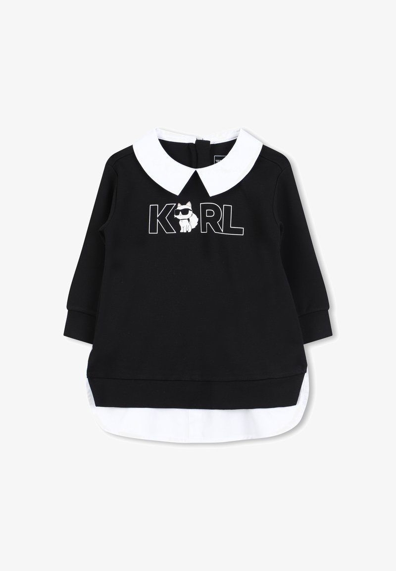 Sudadera negra con cuello blanco, que presenta un logo "KARL" y un gráfico de perro. Mangas largas, diseño en capas con detalle de dobladillo blanco.