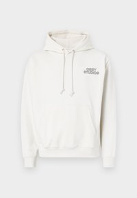 White hoodie made of soft fabric with a front kangaroo pocket, drawstring hood, and "OBEY STUDIOS" logo in black on the chest.
