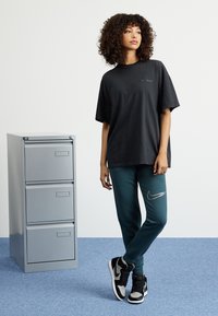 Nike Sportswear CLUB SHINE PANTS - Teplákové kalhoty - deep jungle