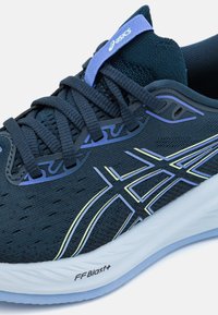 Scarpa sportiva blu scuro con tomaia in mesh, accentuata da dettagli blu chiaro e gialli, e suola ammortizzata FFBlast+ bianca.