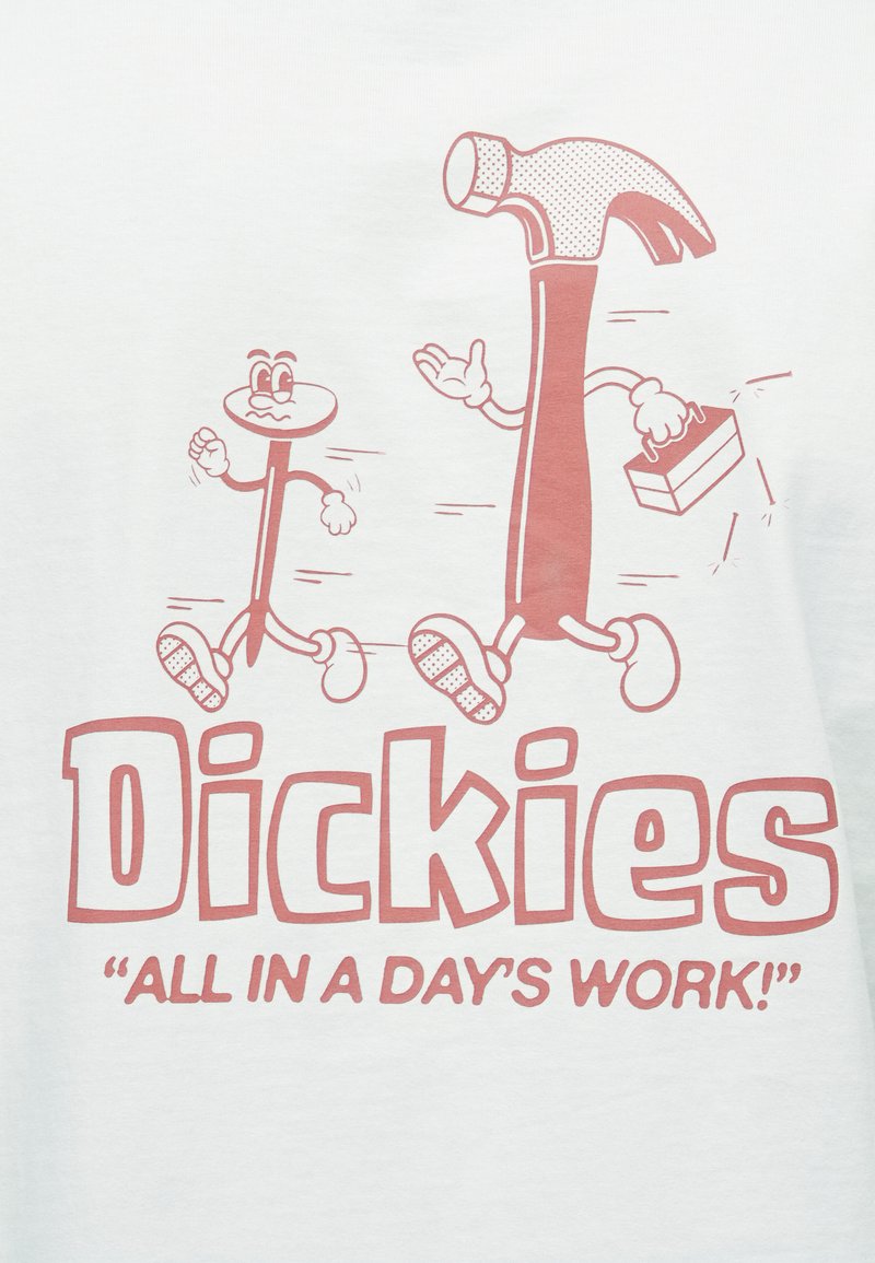 Hvid skjorte med et rødt grafisk motiv af en tegneseriehammer og en figur med øjne. Teksten lyder "Dickies" og "'Alt på en dags arbejde!'"