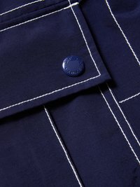 Υφασμα σκούρου μπλε ναυτικού με λευκές ραφές και σκούρο μπλε κουμπί με χαρακτικά "GAP" και "AWAKE NY."