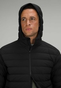Schwarze gepolsterte Jacke mit Kapuze, ausgestattet mit einem durchgehenden Reißverschluss und horizontaler Naht. Der Stoff hat ein mattes Finish und eine glatte Textur.