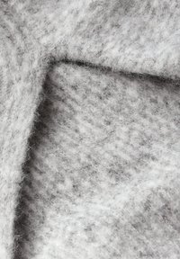 Tessuto lavorato a maglia grigio e bianco con una consistenza morbida e pelosa. Presenta un motivo sottile e fibre visibili, creando un aspetto stratificato.