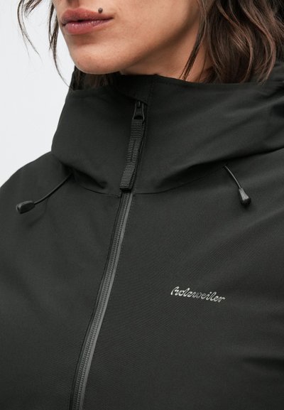 Crna jakna na patentni zatvarač s visokim ovratnikom, podesivim vezicama i suptilnim vezenim logotipom na prsima, izrađena od glatkog materijala.