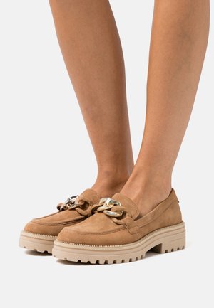 Mocassins en cuir suédé de couleur marron clair avec une semelle en caoutchouc épaisse. Présentent une accentuation décorative en chaîne et un design à bout rond.