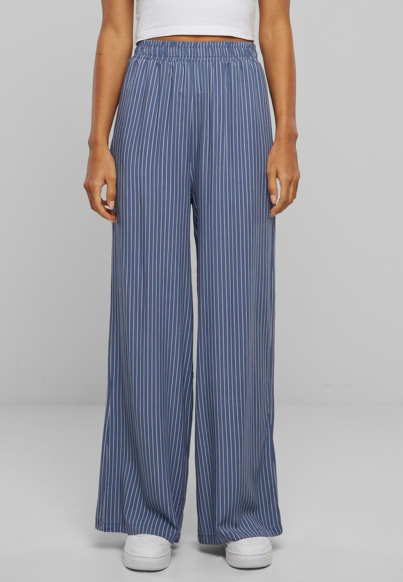 Pantalon à jambe large rayé bleu et blanc avec une taille élastique, en tissu léger, présentant une texture lisse et une coupe longue jusqu'au sol.