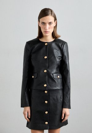 Black leather jacket with gold buttons, featuring a round neckline, front pockets, and a matching skirt with button detail. Smooth texture.