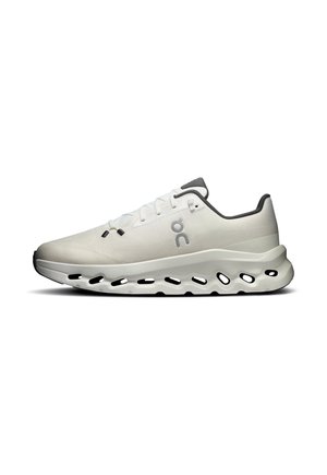 Chaussure de sport blanche avec découpes noires sur la semelle, logo latéral et doublure intérieure noire, vue de l'extérieur sur fond blanc.