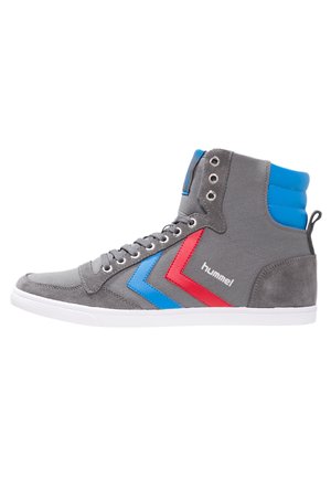 Baskets montantes en daim gris avec des accents en chevron bleu et rouge, semelle en caoutchouc blanc et œillets en métal pour les lacets.