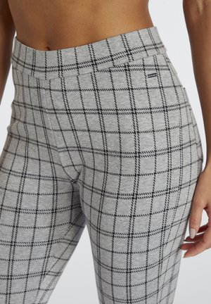 Graue Leggings mit Karomuster in schwarzen Linien, gefertigt aus weichem Stoff mit mittlerer Taille und glatter Textur.