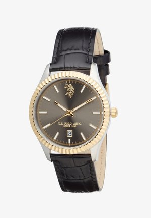 Montre-bracelet ronde avec bracelet en cuir noir, lunette cannelée dorée, cadran gris foncé, index et aiguilles dorés, logo U.S. Polo Assn. et affichage de la date à 6 heures.