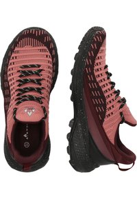 Des chaussures de sport rose et bordeaux avec une tige en tricot texturé, des lacets noirs et une semelle en caoutchouc avec des accents mouchetés. Design à profil bas.