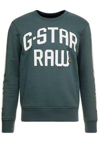 Zelená mikina s bílým nápisem "G-STAR RAW", žebrovanými manžetami a spodním lemem, klasickým kulatým výstřihem a kontrastními bočními panely. Měkká textura materiálu.