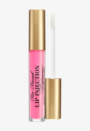 Roze lipvergroterbuis met gouden dop en applicator, gelabeld "Too Faced Lip Injection Extreme" voor directe en langdurige lipvergroting.
