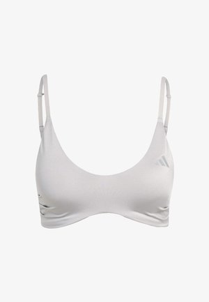 Brassière de sport gris clair avec fines bretelles réglables, encolure arrondie et design sans coutures. Présente un logo de marque subtil dans le coin supérieur.