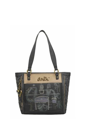 Schwarze und braune Tragetasche mit geprägtem Muster, goldenen Akzenten und grafischen Designs. Die Details umfassen ein Logo und eine dekorative Kette.