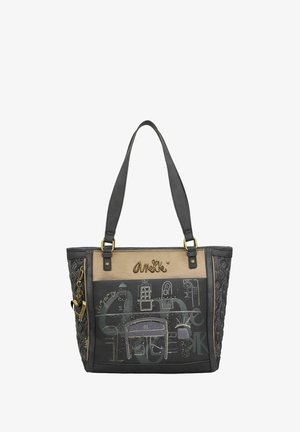 Borsa tote nera e marrone con motivo in rilievo, dettagli dorati e grafiche. I dettagli includono un logo e una catena decorativa.