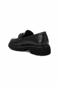 Zwart leren instap schoen met een chunky zool, voorzien van een decoratieve metalen gesp en een gladde textuur. Achteraanzicht toont een ronde hak.