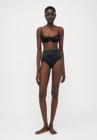 Black lace bra with adjustable straps and a satin high-waisted brief. Smooth texture, fitted design, and minimalistic style.