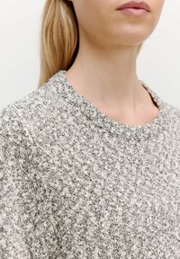 Grau-weißer, strukturierter Strickpullover mit rundem Ausschnitt und aus einem weichen, flauschigen Material gefertigt, das ein dezentes Muster aufweist.