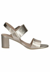 Sandal con tacco a blocco in oro metallizzato, dotata di due cinturini, uno alla caviglia e uno sulla parte anteriore del piede. Texture liscia e design minimalista.