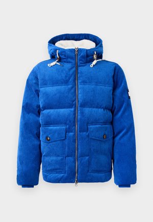 Sininen corduroy-tyylinen toppatakki etuvetoketjulla, kahdella läpällä varustetulla taskulla ja hupulla, joka on vuorattu valkoisella fleece-kankaalla.