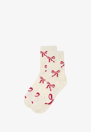 White ankle socks with red bow patterns, soft texture, and ribbed tops. Features multiple small bows evenly spaced across the surface.